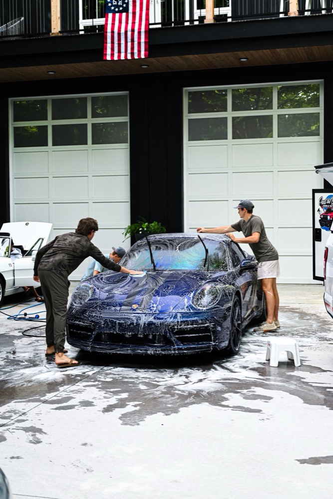 Just The Details crew foam washing a Porsche 911